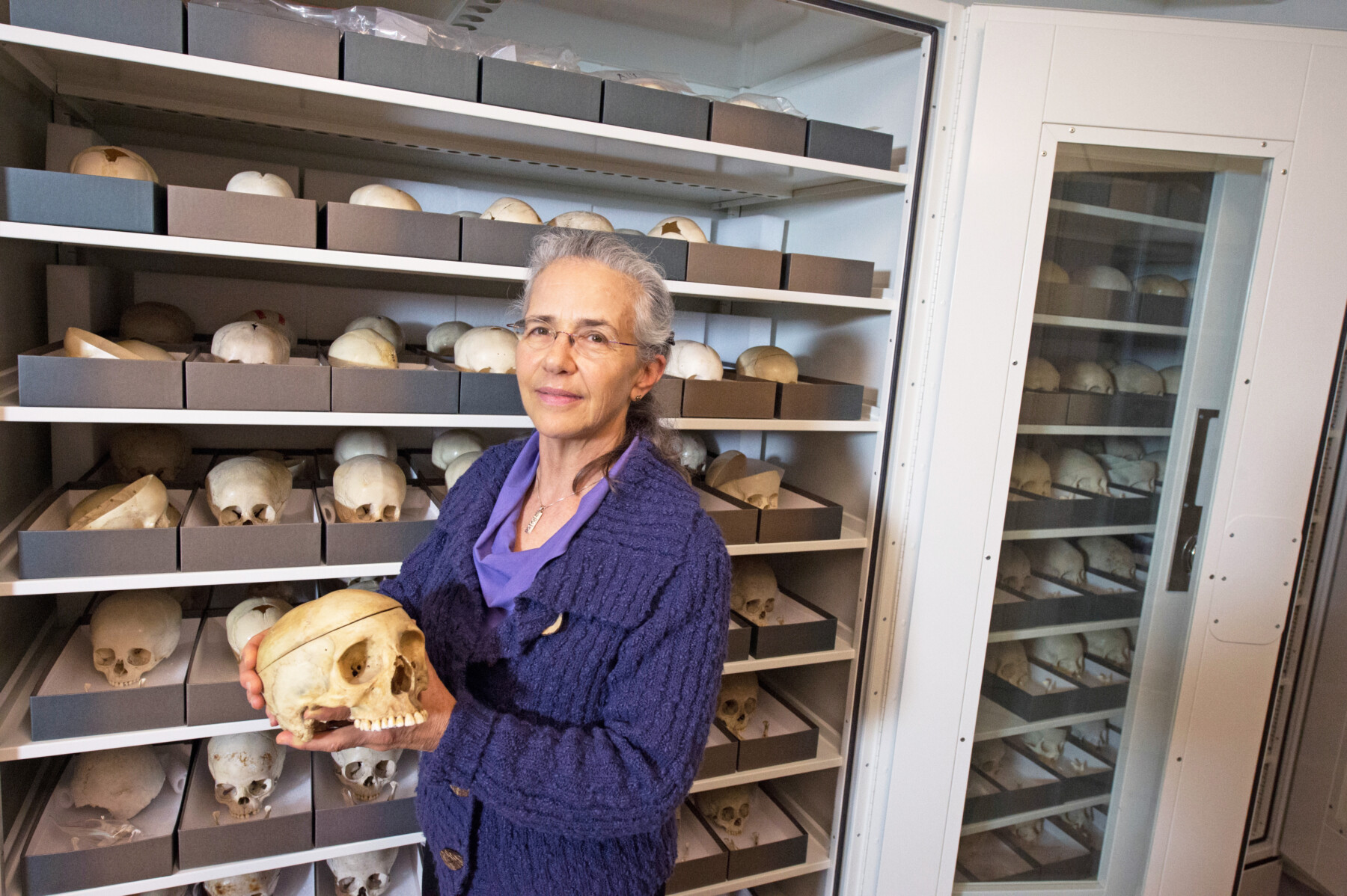 Dodi in front of collection holding a skull