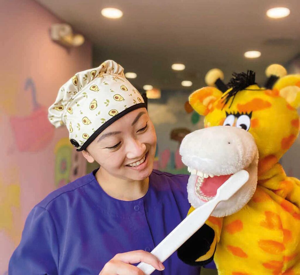 Tiffany Mosqueda ’18 DH demonstrates proper brushing technique to children